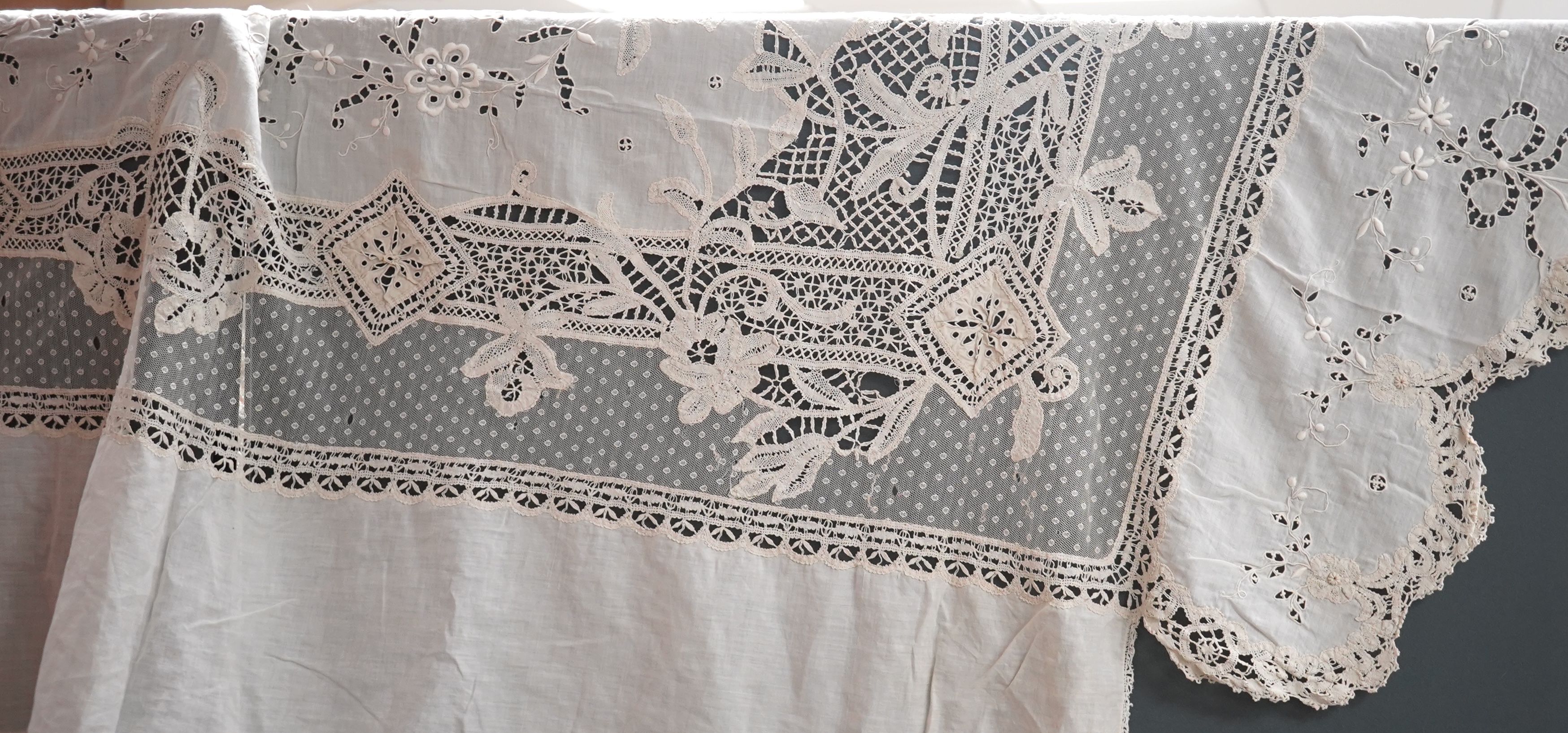 An ornate Edwardian bed cover, handmade from cut work anglaise panels, fine spot motif net and bobbin lace insertions, 228cm wide x 228 cm long. Condition - the spot motif net and fine lawn are damaged in places, the law